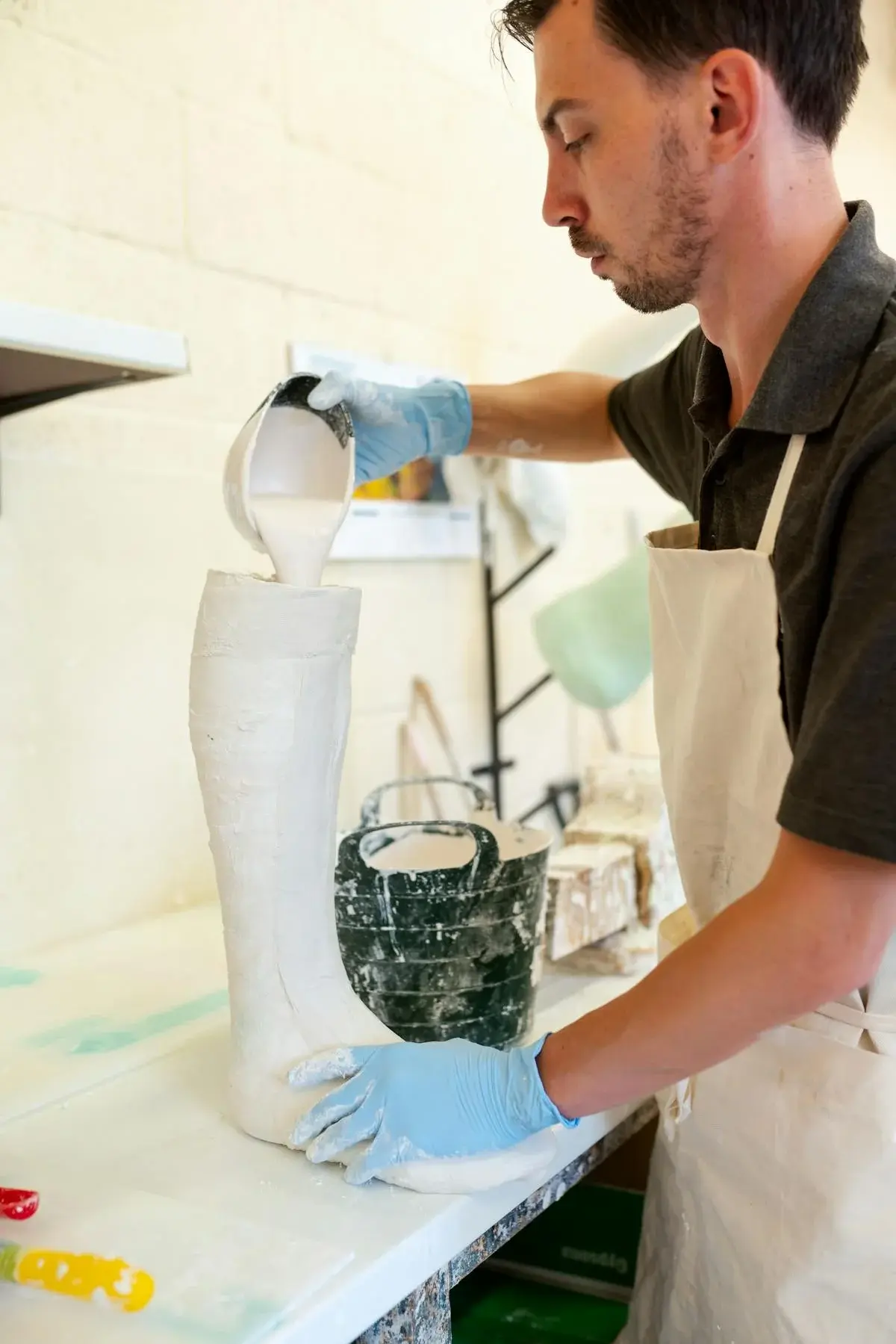 An orthotist pouring plaster into a leg cast mould to create a custom orthotic